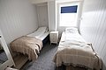 Gemütliches Schlafzimmer in Nordland, Norwegen: Zwei Einzelbetten mit hellen Holzwänden und weichen Decken, bieten Komfort nach einem erlebnisreichen Angeltag. Perfekt für erholsame Nächte im Angelurlaub.