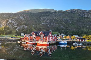 Idyllisches Fischerdorf in Südwest-Norwegen mit rot gestrichenen Häusern, ruhigem Wasser und umliegenden Bergen. Perfekt für einen Angelurlaub mit atemberaubender Naturkulisse und erstklassigen Fangmöglichkeiten. Petri Heil!