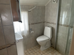 Helles, gefliestes Badezimmer in Nord-Norwegen mit Dusche, Toilette und Waschbecken. Ideal für gemütliche Angelurlaube. Barrierefrei, sauber und funktional gestaltet für Komfort nach einem langen Angeltag.