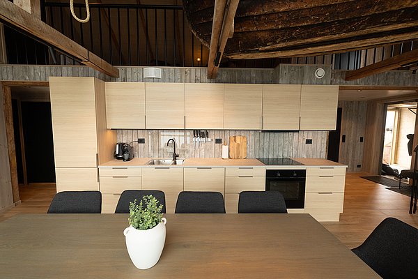 Moderne Küche in Nordland, Norwegen: Helle Holzmöbel, stilvolles Design, große Arbeitsfläche, gemütliches Ambiente. Perfekter Ausgangspunkt für Angelabenteuer in atemberaubender arktischer Landschaft. Ideal für erholsamen Angelurlaub in skandinavischem Stil.