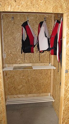 Trockenschrank mit roten Schwimmwesten in einer Holzkabine, ideal für Sicherheit beim Angeln in Hitra, Norwegen. Perfekt für Angelreisen, um optimalen Komfort und sichere Ausflüge zu gewährleisten.