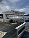 Eine weiße, überdachte Terrasse mit Holzsteg ragt über das Wasser in der malerischen Region Hitra, Norwegen. Perfekt für Angelurlaube und Naturerlebnisse. Ruhiger Ort mit atemberaubender Aussicht auf den Fjord.
