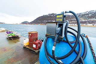 Ein Hafen in Südwest-Norwegen mit Kraftstoffstation, Kanistern und malerischem Blick auf das Meer. Perfekt für Angelreisen mit Boot in unberührter Natur. Ideal für Anglerabenteuer in skandinavischen Gewässern.