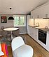 Gemütliche Unterkunft in Hitra, Norwegen: Moderne Küche, runder Esstisch, helle Holzböden, minimalistische Einrichtung. Ideal für Angelurlaub in skandinavischer Natur. Perfekt für erholsame Momente nach erfolgreichen Angelausflügen.