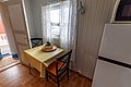 Gemütliche Küche in norwegischem Ferienhaus auf Hitra. Holzvertäfelung, Fenster mit Aussicht, gelb karierter Tisch. Ideal für entspannte Angelurlaube, umgeben von unberührter Natur und herrlichen Angelmöglichkeiten in Norwegen. Perfekt für Abenteuerlustige und Erholungssuchende.