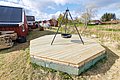 Holzterrasse mit Feuerstelle in malerischer Umgebung in Hitra, Norwegen. Rote Holzhäuser und grüne Wiesen bieten idyllische Atmosphäre für Angelurlaub und Erholung. Entdecke die Schönheit der norwegischen Landschaft.