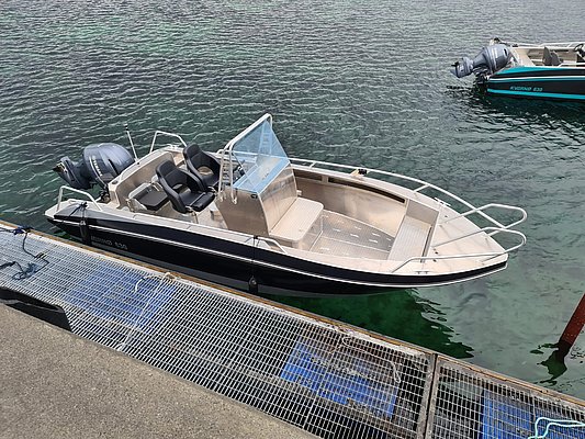 Motorboot am Pier in Nord-Norwegen, perfekt für Angelabenteuer im klaren Wasser. Ideal für Angelreisen, entspannte Bootsfahrten und atemberaubende Naturlandschaften. Robust, komfortabel, bereit für Dein Nordland-Erlebnis.
