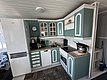 Gemütliche Küche im traditionellen Stil auf Hitra, Norwegen. Helle, grüne Schränke, moderne Elektrogeräte und praktische Einrichtung. Perfekt für Angelurlaub, um frisch gefangenen Fisch zuzubereiten. Optimaler Komfort nach einem erfolgreichen Angeltag.