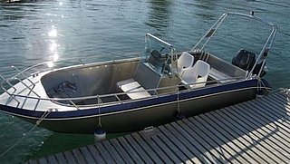 Kleines Motorboot am Holzsteg, bereit für Angelabenteuer auf dem River Shannon in Irland. Perfekt für entspannte Bootsfahrten und Angelurlaub in atemberaubender Naturumgebung.