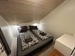 Gemütliches Schlafzimmer in Nord-Norwegen mit zwei Einzelbetten, Holzwänden und Decke. Ideal für erholsame Nächte nach einem spannenden Angelurlaub. Freundliche Atmosphäre lädt zum Entspannen ein. Perfektes Rückzugsziel in Norwegens atemberaubender Natur.