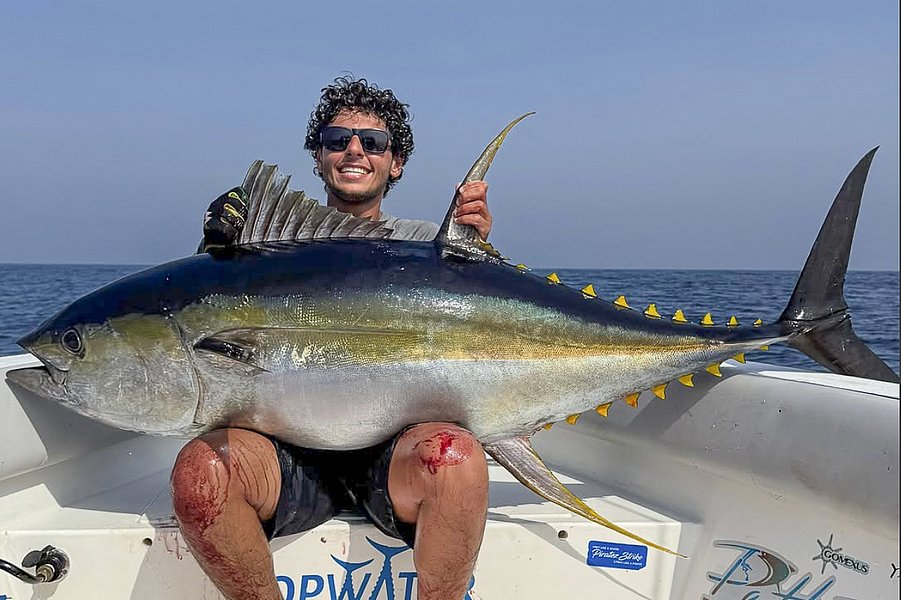 Ein glücklicher Angler hält einen beeindruckenden Gelbflossenthunfisch auf einem Boot vor der Küste Süd-Norwegens. Perfekt für Meeresangeln-Enthusiasten auf der Suche nach Abenteuer und großen Fängen.
