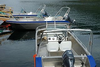 Drei Aluminium-Boote liegen am Steg, ideal für Angeltouren in der Region Hälsingland, Schweden. Perfekt zum Meeresangeln, umgeben von ruhigem Wasser, bereit für unvergessliche Angelabenteuer.