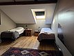 Gemütliches Zimmer in Nord-Norwegen mit zwei Einzelbetten, Dachfenster und Holzboden. Ideal für Angler, die Entspannung nach einem aufregenden Angeltag suchen. Bequemer, rustikaler Charme in wunderschöner Umgebung.