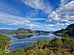Atemberaubender Blick über die fjordreiche Landschaft von Hitra, Norwegen: Blaues Wasser, grüne Hügel und weiße Wolken bieten perfekte Bedingungen für einen erholsamen Angelurlaub in unberührter Natur. Ideal für Angelreisen und Meeresangeln.