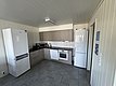 Moderne Küche in Hitra, Norwegen: helle Schränke, geräumiger Kühlschrank, Backofen, Mikrowelle und Spüle. Ideal für Angelurlauber, die Komfort schätzen. Perfekte Ausstattung für selbstgekochte Mahlzeiten nach einem erfolgreichen Angeltag.