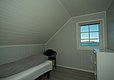 Gemütliches Schlafzimmer auf Hitra, Norwegen, mit Einzelbett, maritimem Ambiente. Fensterblick auf das Meer sorgt für Entspannung und Abenteuerlust. Ideal für Anglerurlauber. Helle, freundliche Holzwände und -decken bieten skandinavischen Charme.