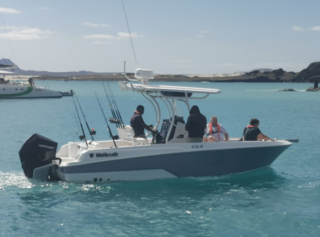 Anglerboot mit mehreren Personen auf türkisblauem Wasser vor der Küste Nord-Norwegens. Ideal für Angelreisen und Meeresangeln. Ein unvergessliches Abenteuer in einer atemberaubenden Landschaft. Perfekt für einen sorgenfreien Angelurlaub.