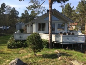 Gemütliches Ferienhaus in Süd-Norwegen mit großer Veranda, umgeben von Wald. Perfekt für Angelurlauber und Naturfreunde, bietet es Erholung in malerischer Umgebung. Ideal für Entspannung nach einem erfolgreichen Tag am Wasser.