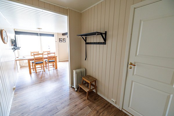 Gemütliches Ferienhaus in Nordland, Norwegen: Helle Holzwände, Esstisch mit Stühlen, moderne Einrichtung. Ideal für erholsamen Angelurlaub in ruhiger Lage. Perfekt für Naturliebhaber und Outdoor-Abenteuer. Authentisches skandinavisches Design für unvergessliche Erlebnisse.