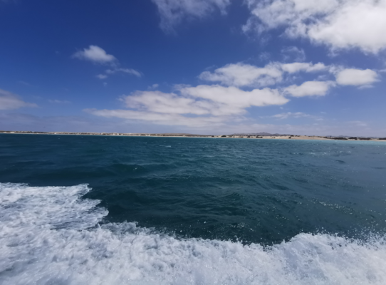 Küstenlinie von São Vicente, Kapverden: Tiefblaues Meer trifft auf helle Sandstrände unter blauem Himmel mit weißen Wolken. Ideal für Angelreisen und Naturliebhaber. Abenteuer am Atlantik erwartet dich.