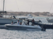 Motorboot in Sao Vicente, Kapverden, bereit zum Angeln im klaren Wasser. Sanddünen und Segelboote im Hintergrund, perfekte Bedingungen für einen Angelurlaub und Abenteuer auf dem Atlantik.