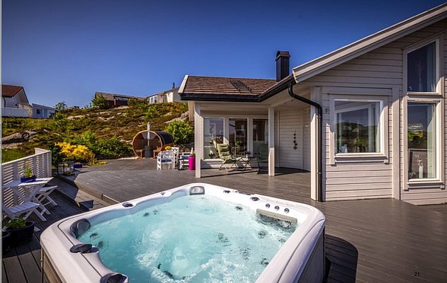 Moderne Ferienhaus-Terrasse in Südwest-Norwegen mit Whirlpool. Sonnenreiche Lage, umgeben von malerischer Natur. Perfekt für erholsame Angelreisen und Entspannung nach erfolgreichen Fängen. Genieße die Ruhe und das skandinavische Design im Urlaub.