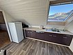 Gemütliche Küche in Hitra, Norwegen, mit modernen Geräten und großem Dachfenster. Traumhafter Bergblick. Ideal für Angelurlauber, die nach Abenteuer und Komfort suchen. Perfekter Ausgangspunkt für Erkundungen der Region und Meeresangeln.