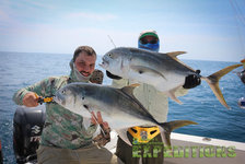 Zwei Angler präsentieren große Fische auf einem Boot vor der Küste Nord-Norwegens. Strahlend blauer Himmel und weite Meereslandschaft im Hintergrund. Ideal für Abenteuer und Angelfreunde. Perfekte Bedingungen für Angelreisen nach Norwegen.