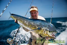 Ein Angler präsentiert stolz einen beeindruckenden Dolphinfish (Mahi-Mahi) auf einem Boot vor den malerischen, blauen Gewässern der Malediven. Perfektes Ziel für Meeresangeln und unvergessliche Angelabenteuer auf den Malediven.