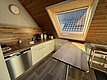 Gemütliche Küche in Hitra, Norwegen mit Holzverkleidung, Dachfenster für Tageslicht, moderner Ausstattung und Sitzgelegenheit. Ideal für Angler auf der Suche nach Komfort und Funktionalität in ihrer Ferienunterkunft.