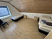 Gemütliches Zimmer in Hitra, Norwegen, mit zwei Betten, Holzdecke und großem Fenster. Perfekt für Angler, die Ruhe und Komfort suchen. Ideal gelegen für den nächsten Angelurlaub.
