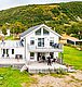 Modernes Ferienhaus in Nordland, Norwegen, umgeben von grünen Hügeln und landschaftlicher Ruhe. Perfekte Unterkunft für einen Angelurlaub, mit großzügiger Terrasse und malerischem Ausblick. Entspannung und Natur pur erleben.