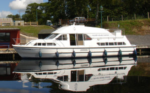 Hausboot am River Erne in Irland, ruhig am Ufer angedockt. Ideal für Angelurlaub, umgeben von grüner Natur und spiegelndem Wasser, perfekte Erholung und Abenteuer in malerischer Umgebung.