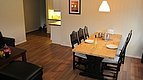 Gemütliches Esszimmer in Hitra, Norwegen: Holztisch mit acht Stühlen, einladende Atmosphäre, angrenzende moderne Küche. Perfekt für Angelurlauber, die nach einem erfolgreichen Angeltag gemeinsam entspannen möchten. Ideal gelegen für Abenteuer und Erholung.