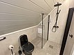 Modernes Badezimmer in Nord-Norwegen mit schwarzer Toilette, geräumiger Dusche und stilvollem Design. Perfekt für Entspannung nach einem erfolgreichen Angeltag. Skandinavische Eleganz trifft auf Funktionalität in einem gemütlichen Rückzugsort. Ideal für Angelurlaubsunterkünfte.
