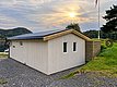 Gemütliches Ferienhaus in Hitra, Norwegen: Holzhütte am Wasser, umgeben von grüner Natur und Fjorden. Perfekt für Angelreisen und Naturliebhaber. Skandinavisches Ambiente bei Sonnenuntergang. Ideal für entspannten Angelurlaub in faszinierender Umgebung.