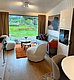 Gemütliches Wohnzimmer auf Hitra mit Panoramablick ins Grüne. Moderne Einrichtung mit bequemen Sesseln, Sofa und dekorativem Teppich. Perfekt zum Entspannen nach einem erlebnisreichen Angelurlaub in Norwegen.