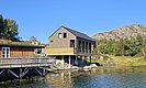 Küstenhütte in Hitra, Norwegen: modernes Holzhaus mit Terrasse am Wasser, umgeben von Felsen und grüner Natur. Ideal für Angelreisen und Entspannung in malerischer Landschaft. Perfekte Unterkunft für Abenteuer und Erholung.