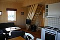 Gemütliches Ferienhaus in Nordland, Norwegen, mit Holzinterieur, Küche, Sitzecke und Treppe. Ideal für Angelreisen, bietet es Ruhe und Komfort nahe der beeindruckenden Naturkulisse der Region. Perfekt für entspannte Abende nach erfolgreichen Angelausflügen.