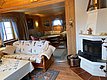 Gemütliche norwegische Ferienhütte in Hitra mit rustikalem Holzwänden, Kamin und einladenden Sofas. Perfekt für Angelreisende, die nach einem erfolgreichen Tag im Freien Entspannung suchen. Ideal für einen erholsamen Angelurlaub in Norwegens wilder Natur.