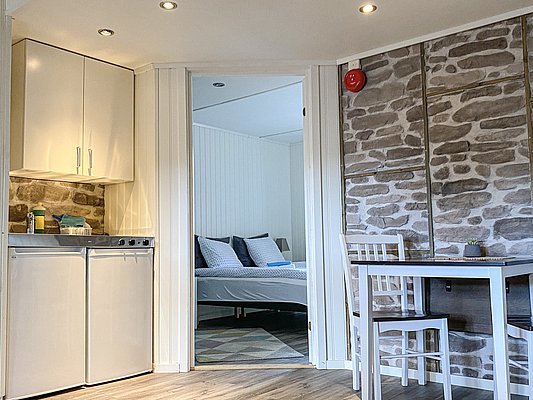Gemütliches Ferienhaus in Nord-Norwegen: Moderne Küche, einladender Essbereich und Schlafzimmer mit Doppelbett. Perfekt für Angelurlauber, die Komfort und Entspannung nach aufregenden Angelausflügen suchen. Ideal für Meeresangeln-Abenteuer in atemberaubender Natur.
