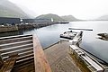Nordland, Norwegen: Ein ruhiger Fjord mit Bootssteg, umgeben von Bergen und modernen Gebäuden. Ideal für Angelreisen und Entspannung in unberührter Natur. Perfekter Ausgangspunkt für Meeresabenteuer.