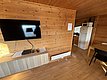 Gemütliche Holzhütte in Hitra, Norwegen. Innenansicht mit TV, Möbeln und moderner Küche. Perfekter Rückzugsort für Angler und Naturliebhaber. Ideal für erholsame Angelreisen und unvergessliche Abenteuer in der Region Hitra.