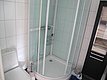 Kompaktes, modernes Badezimmer mit Dusche, WC und Stauraum. Helle Fliesen und klare Struktur bieten Komfort. Ideal für Angler auf Reisen in Nordland, Norwegen. Entspannung nach einem erfolgreichen Tag beim Meeresangeln.