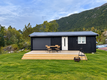 Kleines schwarzes Holzhaus in Hitra, Norwegen, vor grüner Waldkulisse. Holzterrasse mit Tisch und Stühlen, perfekter Ort zum Entspannen in der Natur. Ideal für Angelurlaub und Erholung abseits des Alltags.