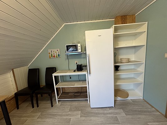 Gemütliche Küchenzeile in Hitra, Norwegen: Kühlschrank, Mikrowelle und Regal bieten praktische Ausstattungen für Angelurlauber. Perfekt für Selbstversorger und Komfort-Liebhaber in der malerischen Umgebung. Ideal für entspannte Mahlzeiten nach erfolgreichen Angelausflügen.