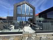 Modernes Ferienhaus in Südwest-Norwegen, mit großer Glasfassade und gemütlicher Terrasse aus Stein und Glas. Ideal für Angelurlaub mit fantastischer Aussicht. Perfekt zum Entspannen und Genießen der norwegischen Küstenlandschaft.