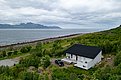 Gemütliches Ferienhaus am Fjord in Nord-Norwegen, umgeben von grüner Natur mit beeindruckenden Bergblicken und direktem Zugang zum Meer. Perfekter Ausgangspunkt für Angelabenteuer und Entspannung in malerischer Landschaft.