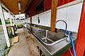 Edelstahl-Fischreinigungsstation in Nord-Norwegen mit Waschbecken und überdachtem Außenbereich. Ideal für Angelurlaube, bietet sie praktische Ausstattung zur Fischverarbeitung nach erfolgreicher Angeltour. Perfekte Kombination aus Funktionalität und authentischem Angelabenteuer.