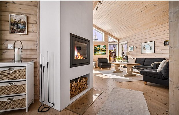 Gemütliches Wohnzimmer in Südwest-Norwegen mit Holzwänden, Kaminfeuer und stilvoller Einrichtung. Einladende Atmosphäre für entspannte Angelabende nach einem erfolgreichen Tag auf dem Wasser. Ideal für Angelreisen und Abenteuer in Norwegens atemberaubender Natur.
